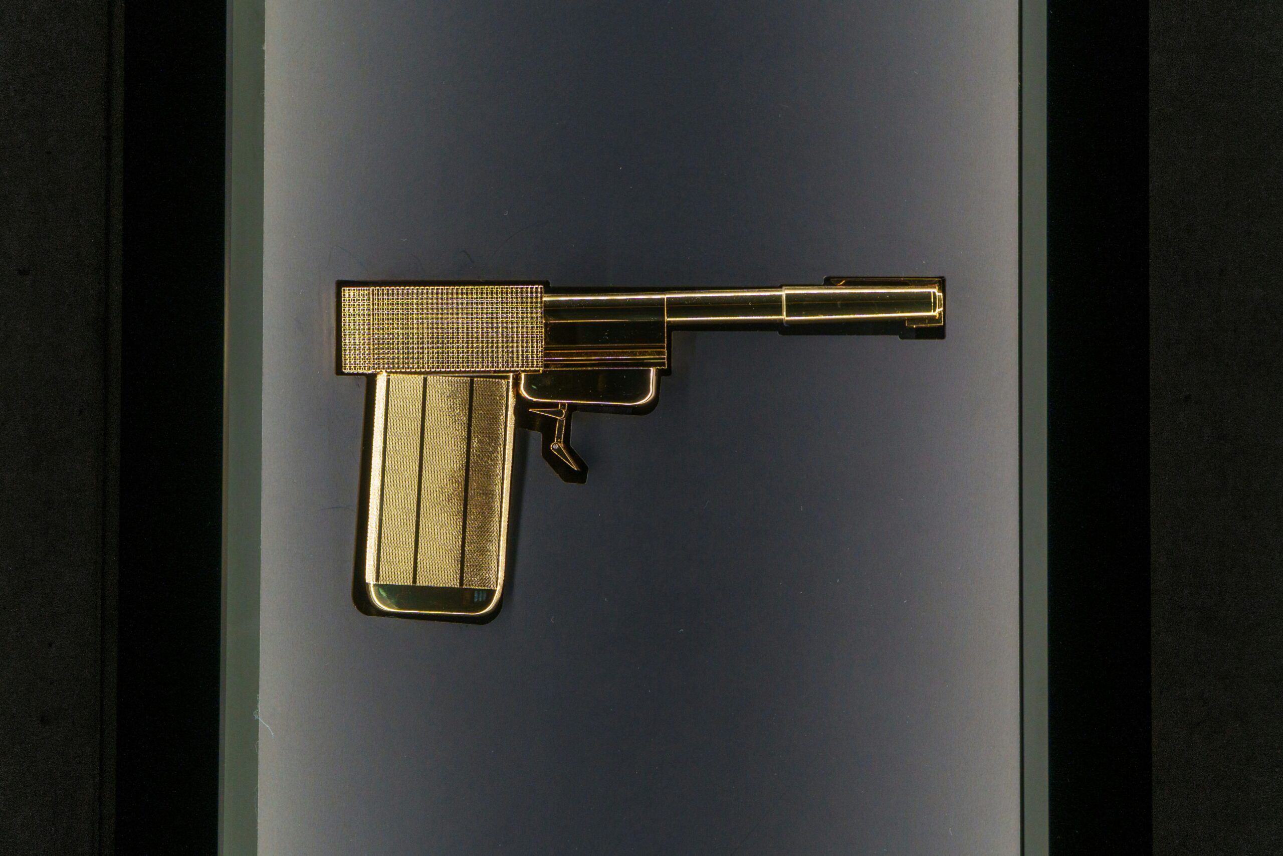 Gold-colored handgun silhouette displayed inside a gun safe, minimalist security-themed design.